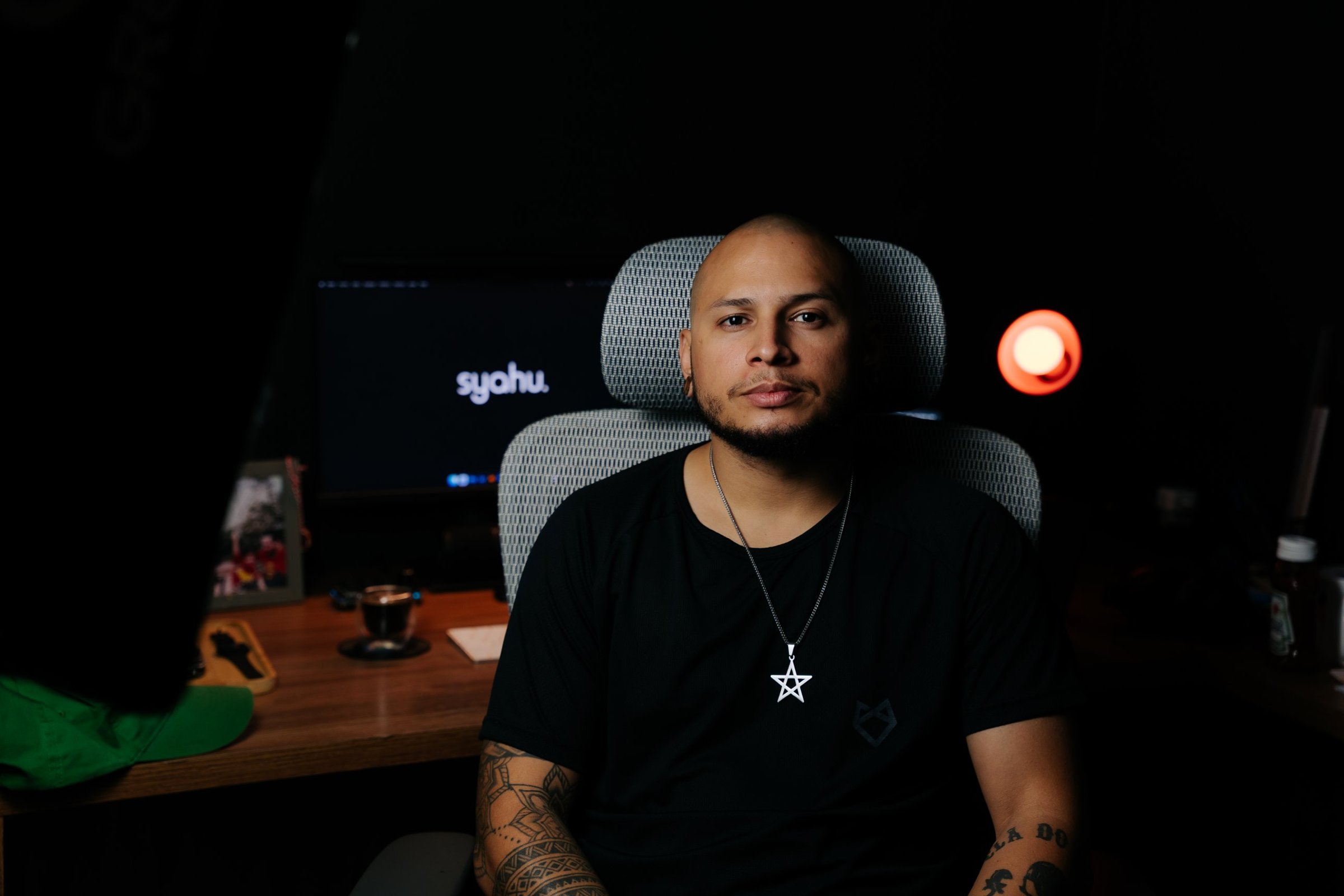 Fundador da Syahu no estúdio, com o logo da agência no monitor ao fundo